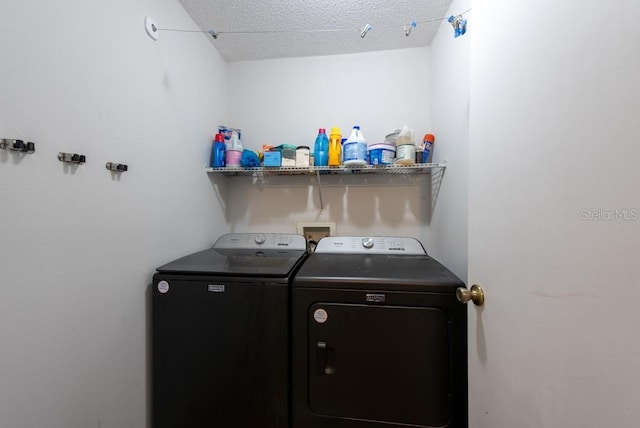 laundry room featuring laundry area, washing machine and dryer, and a textured ceiling