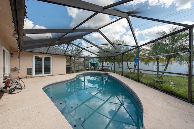 view of pool with a fenced in pool, glass enclosure, a patio, a fenced backyard, and a water view