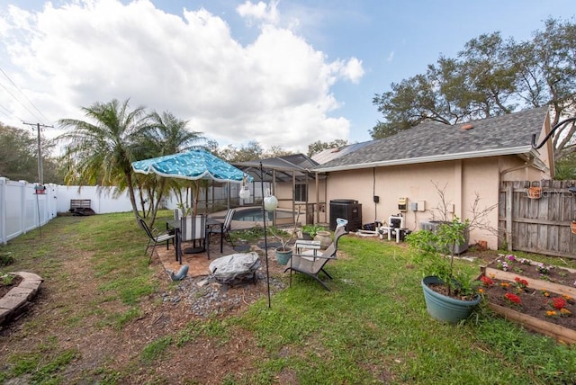 view of yard featuring a fenced in pool, a fenced backyard, glass enclosure, and central air condition unit