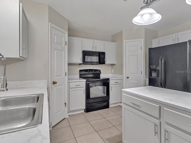 kitchen featuring light tile patterned floors, hanging light fixtures, white cabinets, a sink, and black appliances