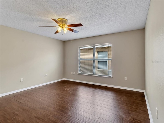 empty room with ceiling fan, dark wood-style flooring, a textured ceiling, and baseboards