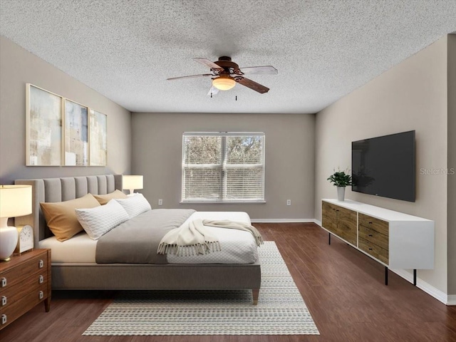 bedroom with a ceiling fan, a textured ceiling, baseboards, and dark wood-type flooring