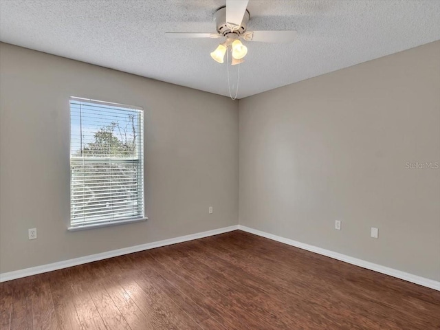 empty room featuring a textured ceiling, ceiling fan, wood finished floors, and baseboards