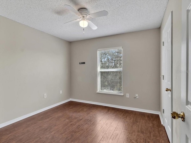 empty room featuring a textured ceiling, ceiling fan, dark wood finished floors, and baseboards