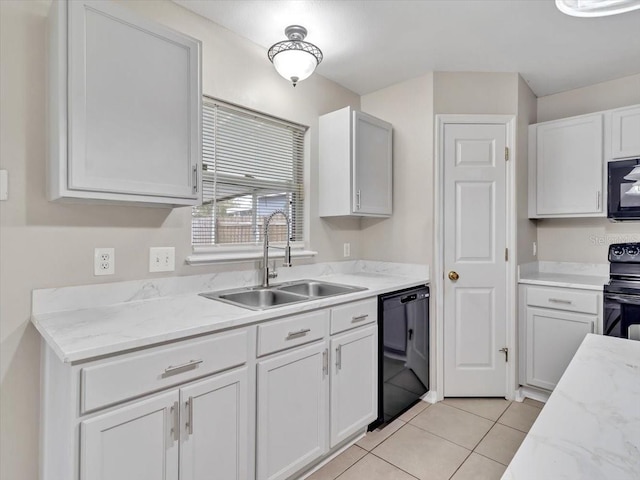 kitchen with a sink, black appliances, light tile patterned flooring, white cabinetry, and light stone countertops