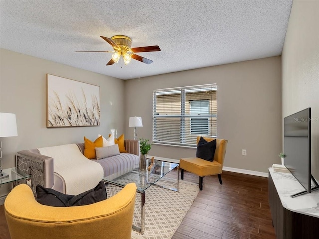living area featuring ceiling fan, wood finished floors, a textured ceiling, and baseboards
