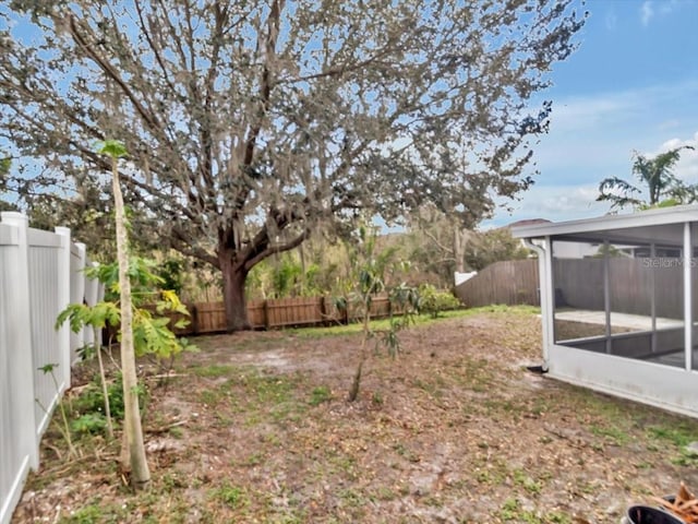 fenced backyard with a sunroom
