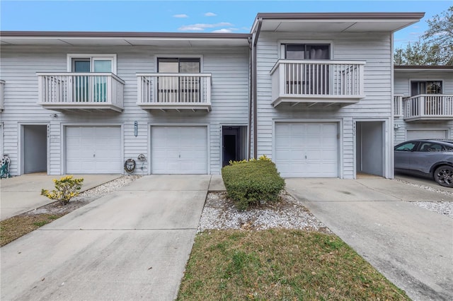 multi unit property featuring a garage and driveway