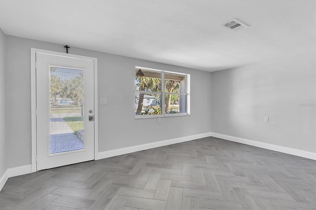 spare room featuring visible vents and baseboards