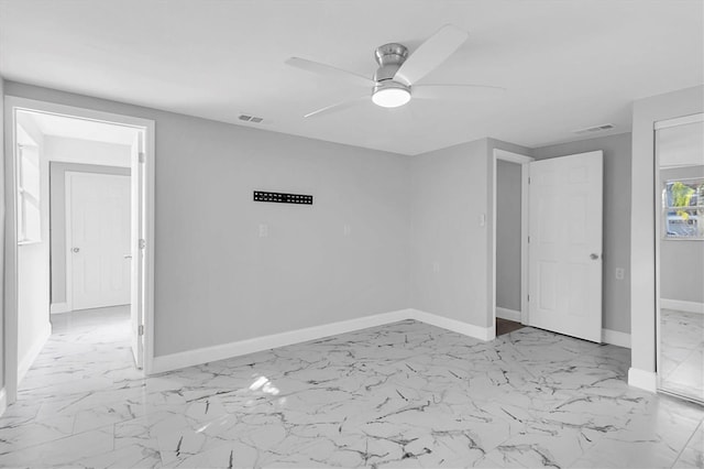 unfurnished bedroom featuring marble finish floor, baseboards, visible vents, and a ceiling fan