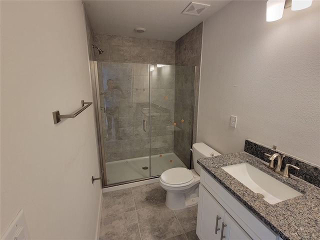 bathroom featuring vanity, toilet, visible vents, and a shower stall