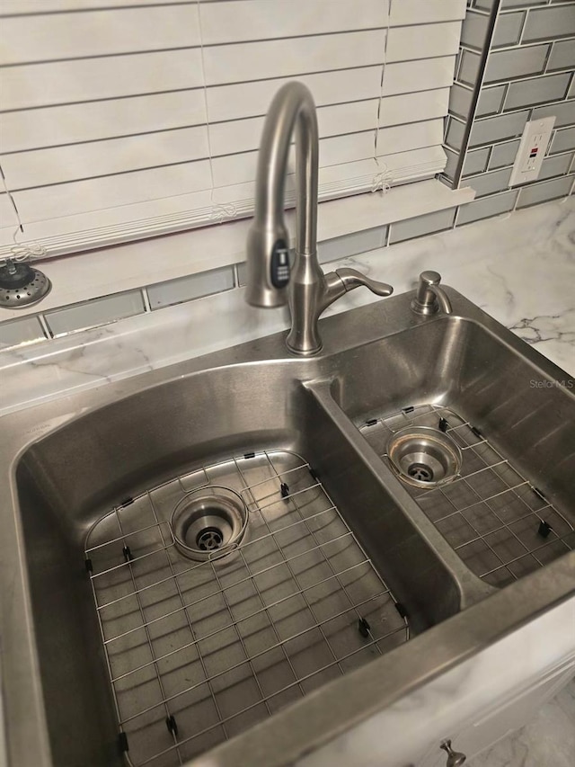 interior details featuring tasteful backsplash and a sink