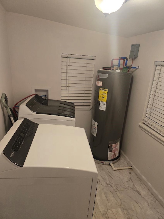 clothes washing area featuring marble finish floor, baseboards, separate washer and dryer, electric water heater, and laundry area