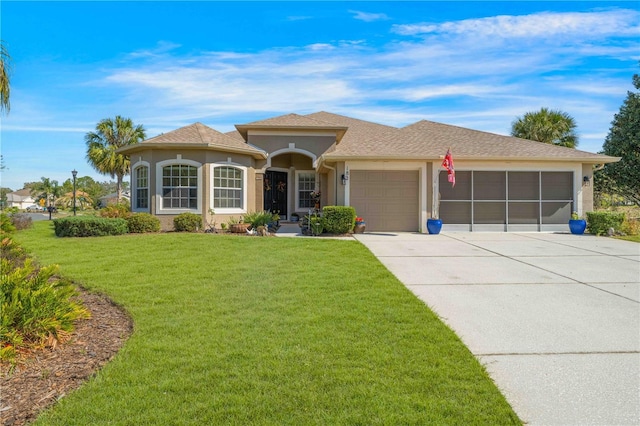 view of front of house featuring a garage, driveway, a front lawn, and stucco siding