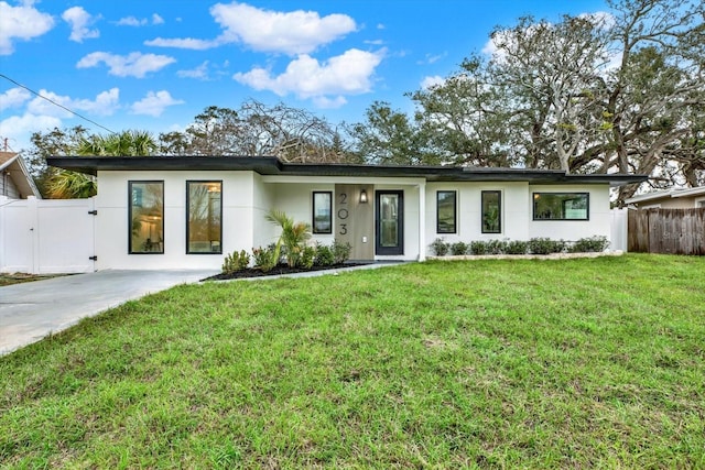 view of front of house featuring a gate, a front yard, fence, and stucco siding