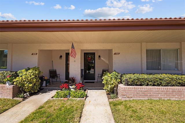 doorway to property featuring stucco siding