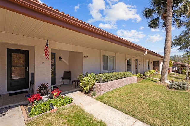 exterior space with stucco siding and a yard