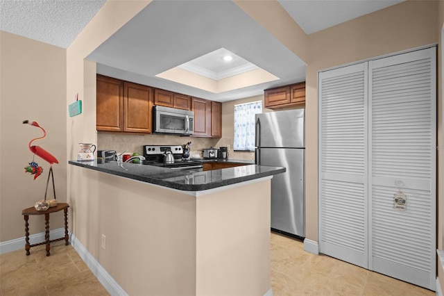 kitchen with stainless steel appliances, brown cabinetry, and a peninsula