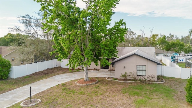 exterior space with a patio area, a fenced backyard, concrete driveway, and stucco siding