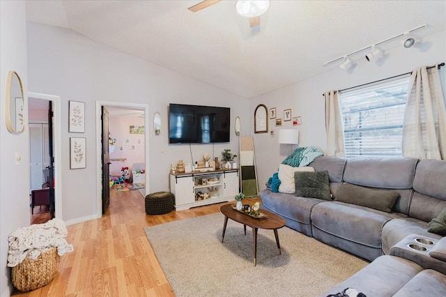 living room with vaulted ceiling, ceiling fan, light wood-type flooring, and track lighting