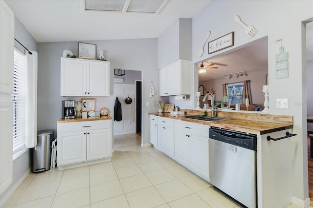 kitchen featuring dishwasher, wood counters, a healthy amount of sunlight, white cabinetry, and a sink