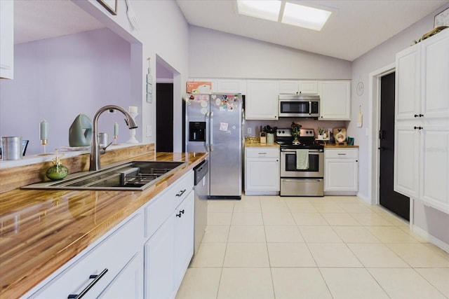 kitchen with stainless steel appliances, white cabinetry, and a sink