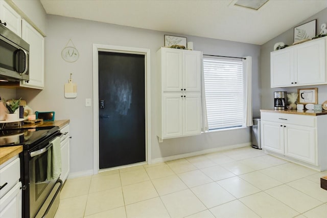 kitchen featuring appliances with stainless steel finishes, white cabinets, and baseboards