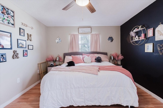 bedroom featuring ceiling fan, light wood-type flooring, and baseboards