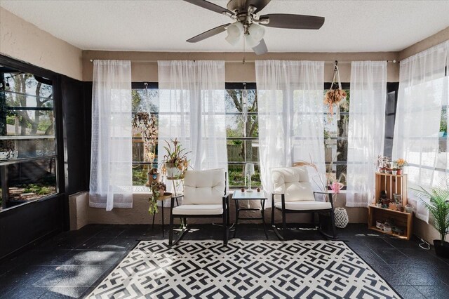 sunroom / solarium featuring a ceiling fan