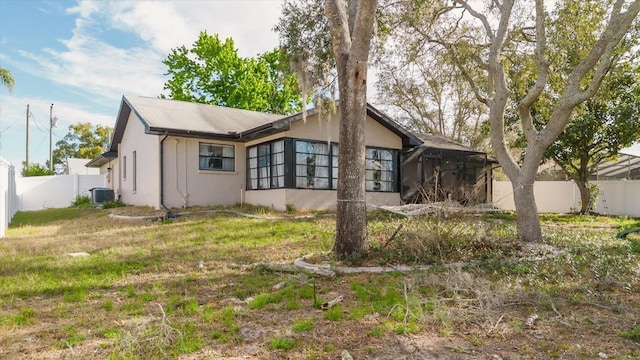 view of front facade with fence, a front lawn, and central air condition unit