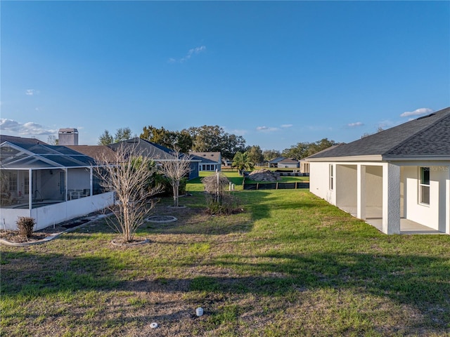 view of yard featuring a patio, a lanai, and a residential view