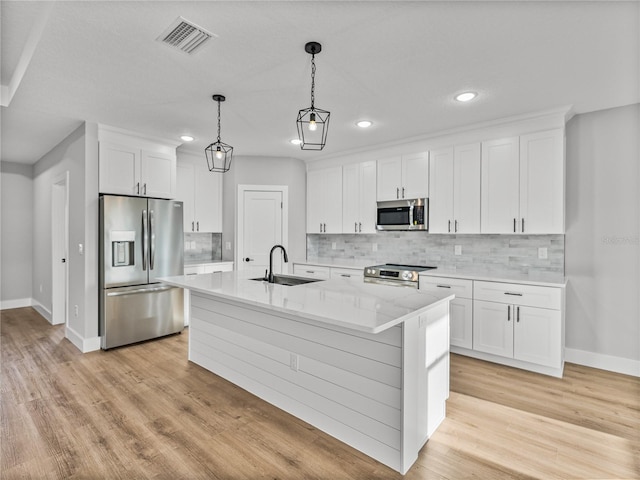 kitchen with stainless steel appliances, a sink, visible vents, and white cabinetry