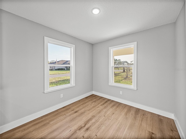 empty room featuring light wood finished floors and baseboards