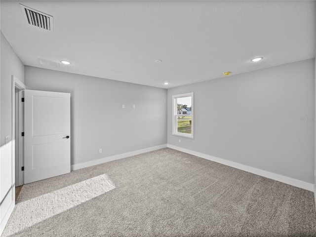 carpeted empty room with recessed lighting, visible vents, and baseboards