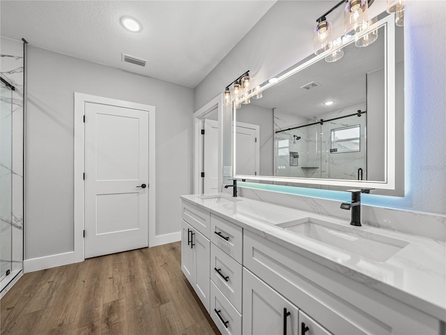 full bathroom with visible vents, a sink, and a marble finish shower