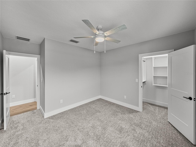 unfurnished bedroom featuring baseboards, visible vents, and light colored carpet