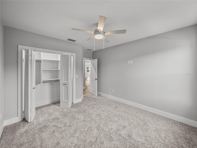 unfurnished bedroom with a closet, visible vents, a ceiling fan, carpet flooring, and baseboards