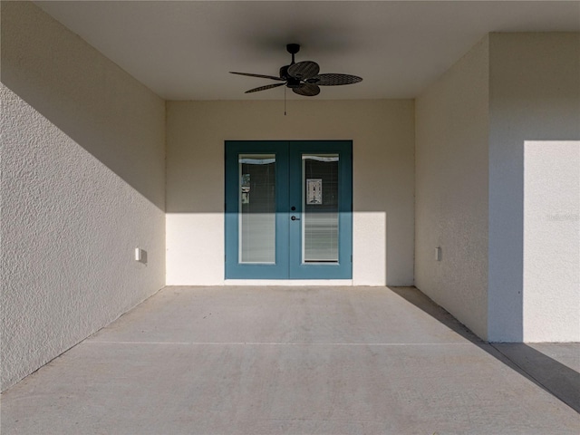 entrance to property with ceiling fan, a patio, french doors, and stucco siding