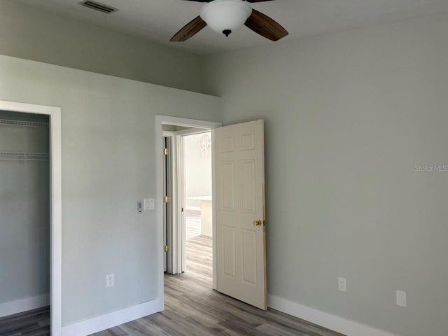 unfurnished bedroom featuring a ceiling fan, visible vents, baseboards, a closet, and light wood-type flooring