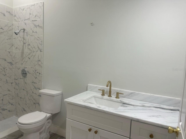 bathroom featuring toilet, a shower stall, and vanity