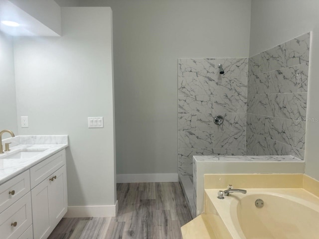 full bath with baseboards, tiled shower, wood finished floors, a garden tub, and vanity