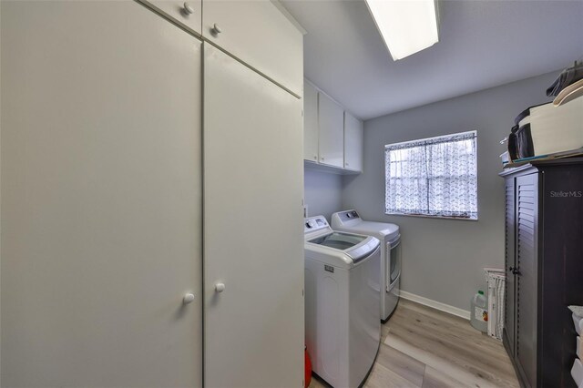 1805 Columbine Pl, Sun City Center, FL 33573 - laundry area featuring light wood-type flooring, cabinet space, baseboards, and washer and clothes dryer