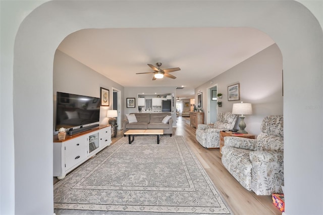 1805 Columbine Pl, Sun City Center, FL 33573 - living room with light wood-style flooring, arched walkways, and a ceiling fan