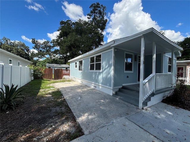 view of front of house with crawl space, fence, and a patio