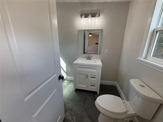 bathroom featuring toilet, vanity, and baseboards