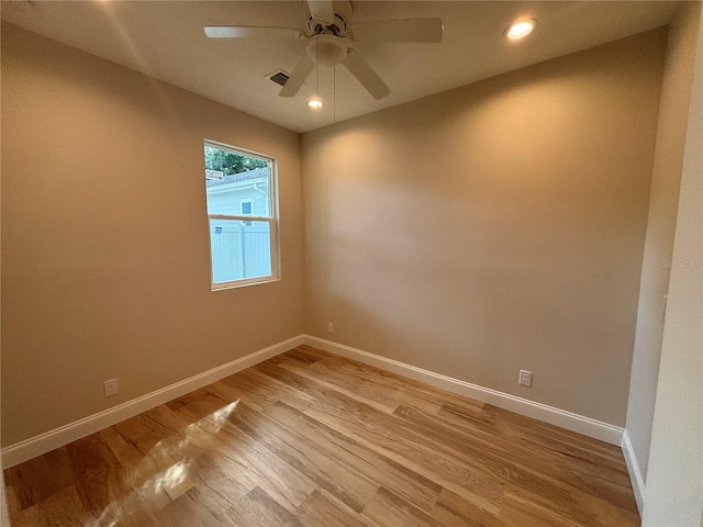 empty room featuring a ceiling fan, light wood-style flooring, and baseboards