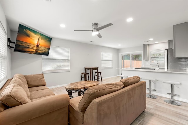 living area featuring baseboards and recessed lighting