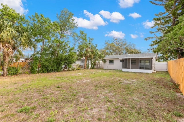 view of yard featuring a sunroom and a fenced backyard