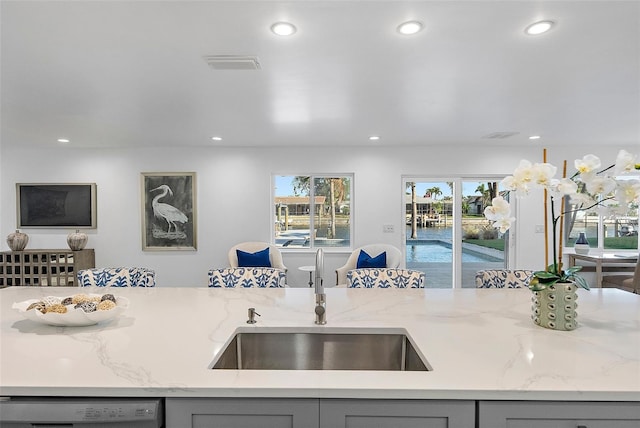 1984 Kansas Ave NE, Saint Petersburg, FL 33703 - kitchen with a sink, light stone counters, gray cabinets, and dishwasher