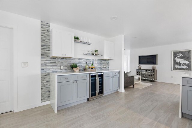 1984 Kansas Ave NE, Saint Petersburg, FL 33703 - bar featuring wine cooler, light wood finished floors, tasteful backsplash, a bar, and baseboards